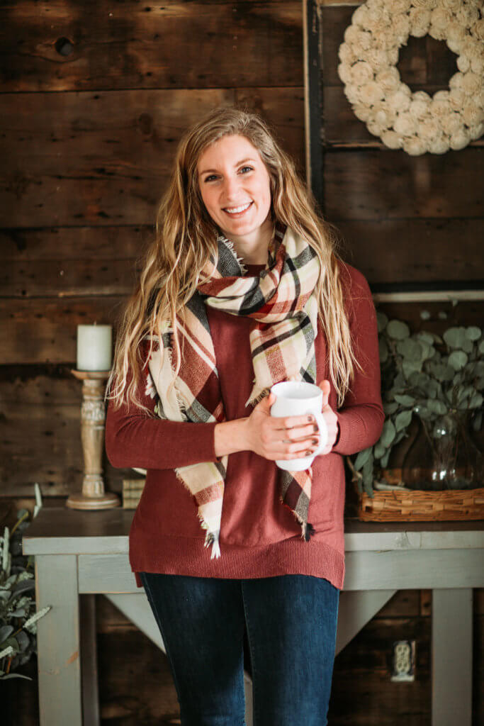 Kelly Wittman holds a coffee cup in front of a table. Providing self branding tips