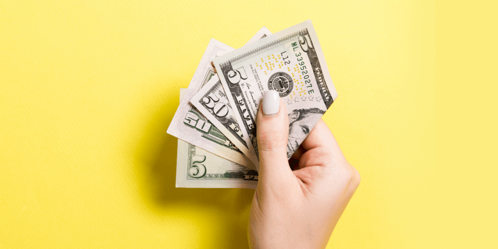 Header image - hand holding wad of money on yellow background